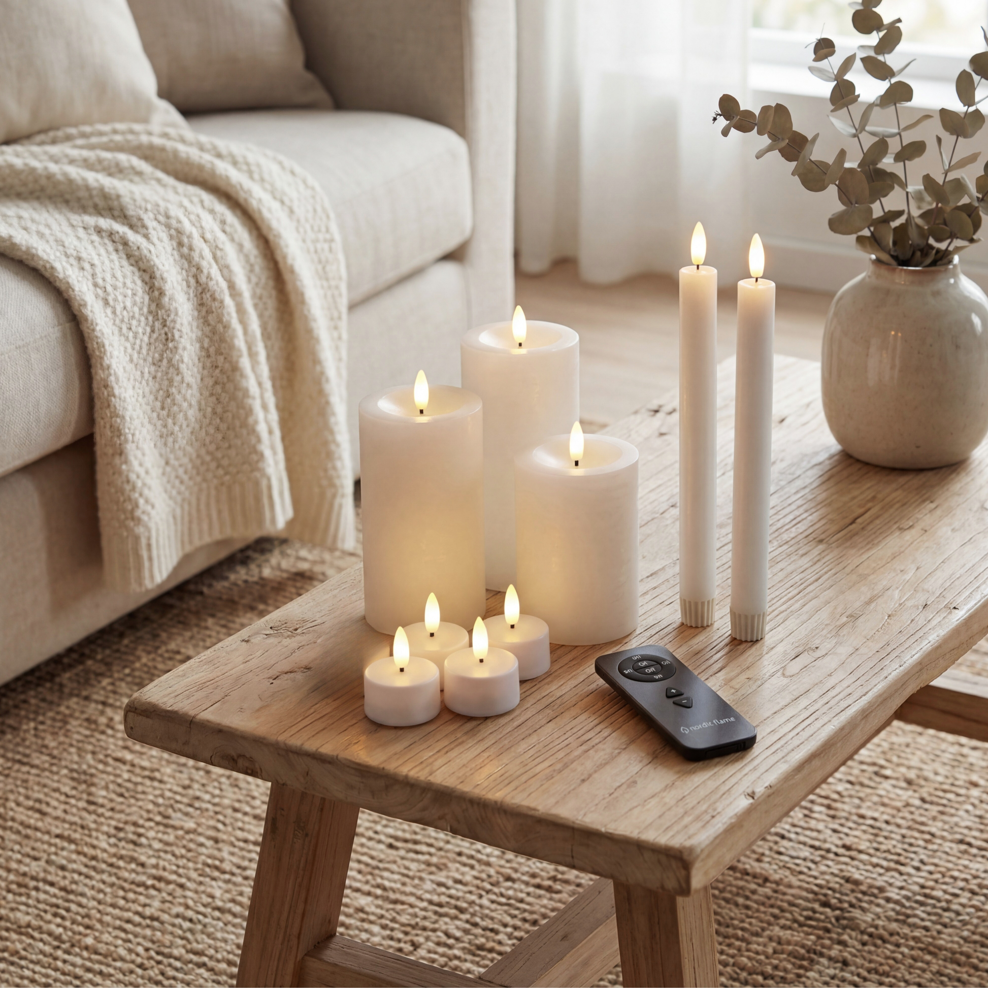 Set van witte Nordic Flame LED-kaarsen met afstandsbediening op houten salontafel in sfeervol interieur.