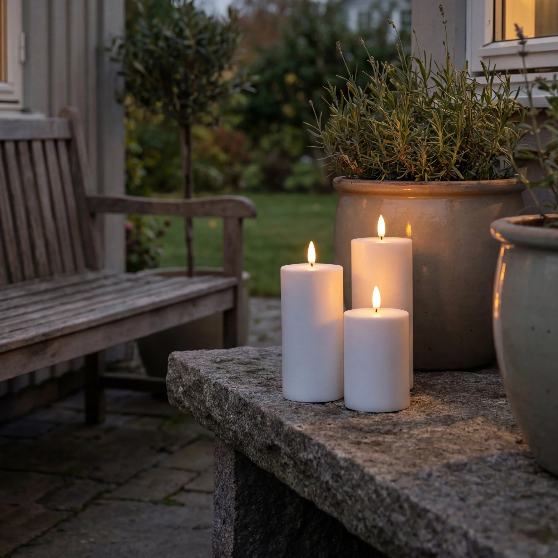Set van drie witte Nordic Flame LED-kaarsen met 3D-vlam op tuintafel, buiten-setting