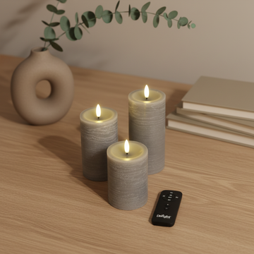 Grijze LED-stompkaarsen met 3D-vlam op houten tafel, afstandsbediening en Scandinavisch decor.