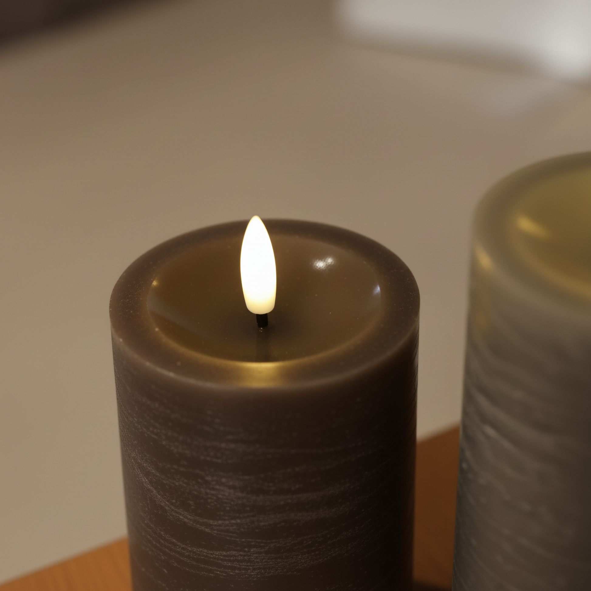 Bruine LED-stompkaars met realistische 3D-vlam van Nordic Flame op een houten ondergrond