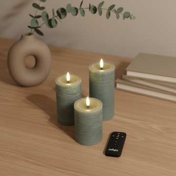 Set van drie groene LED-stompkaarsen met 3D-vlam, afstandsbediening en Scandinavisch decor op houten tafel